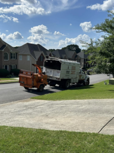 A Sergeant tree service truck with an attached wood chipper parked on a residential street in Atlanta, GA