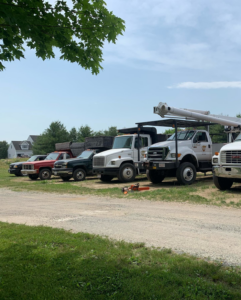 A line of tree service trucks and equipment, including a bucket truck, at Fisk Tree Service in Ahwahnee, CA
