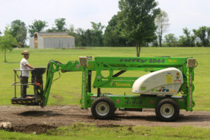 A Cobra Tree Service worker in an aerial lift preparing for tree trimming in Memphis, TN.