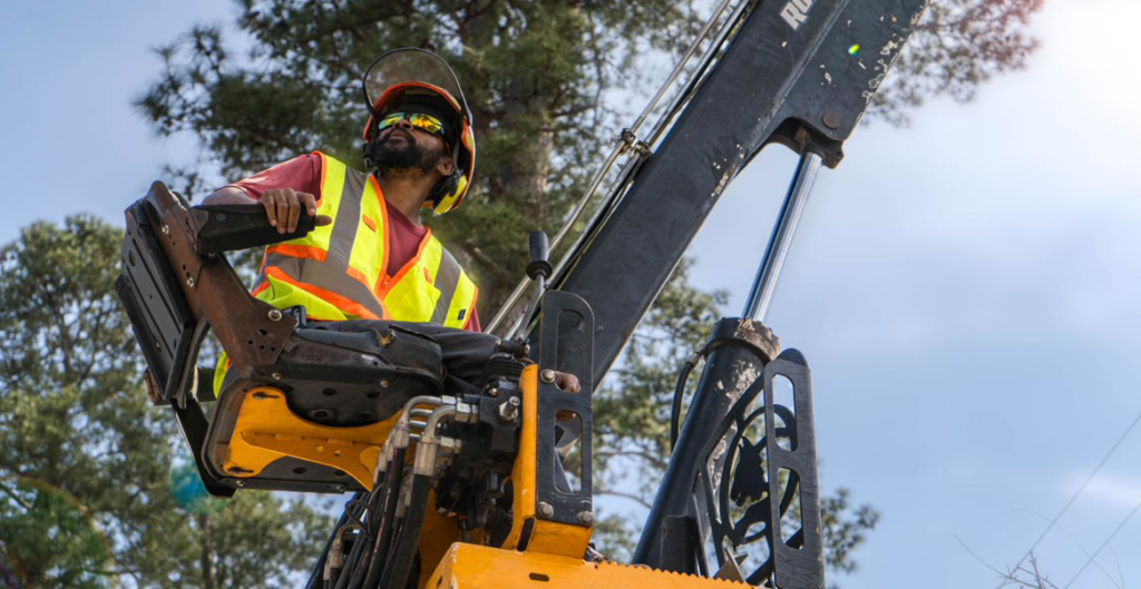 A tree service worker in safety gear operating heavy equipment for Hall's Tree Service, INC in Fayetteville, NC.