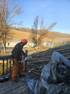 Tree service worker with chainsaw on deck after tree removal by Poppen Tops Tree and Home Solutions in Kingsport, TN