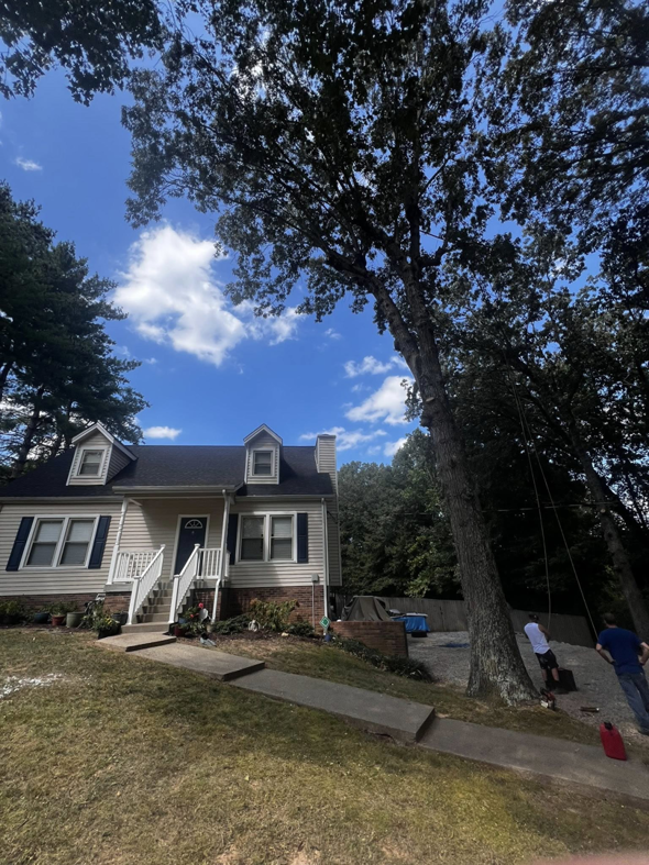 Tree service workers preparing to prune or remove a large tree near a residential home by Carmack Tree and Debris in Clarksville, TN.