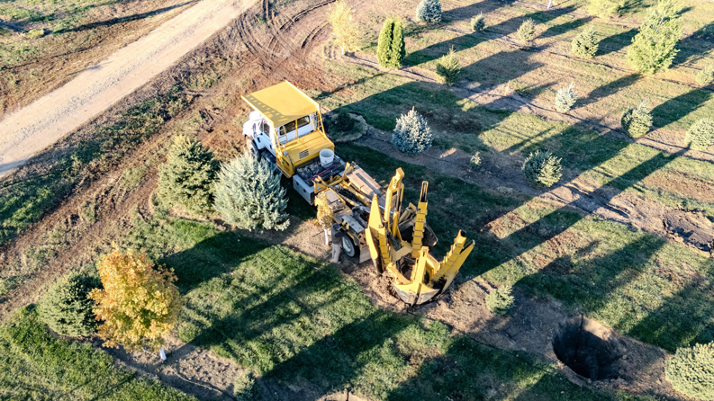 An aerial view of a large tree spade machine transplanting a tree at Hartington Tree in Yankton, SD.