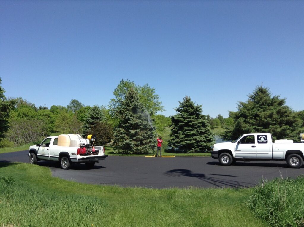 A worker spraying a tree with treatment from a truck, provided by Arborscape Tree Care in Ankeny, IA.