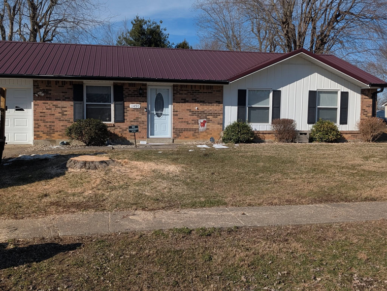 A freshly cut tree stump visible in the front yard of a residential home, indicating recent tree removal by Affordable Tree Service LLC in Saint Charles, MO.