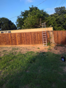 A freshly cut tree stump and wood debris in a backyard after tree removal by Mauricio tree service in Dallas, TX.