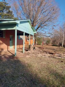 A residential property showing a large tree stump and disturbed ground from tree removal by Jacinto's Tree Services in Montgomery, AL.
