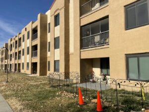 A tree stump marked with caution tape and cones after a tree removal service by Green Peak Landscaping LLC in Kaysville, UT.