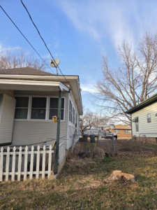 A freshly cut tree stump in a residential yard with a tree service truck visible in the background, completed by Garcia's Tree service in Louisville, KY.