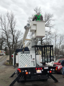 A tree trimmer in a bucket lift performing tree service for Quality Tree Care, Inc. in Pleasant Hill, CA.