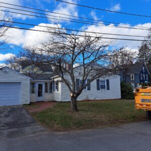 A tree with a fresh cut from trimming, with a chipper truck nearby, performed by Collins Tree Service, Inc. in Hooksett, NH.