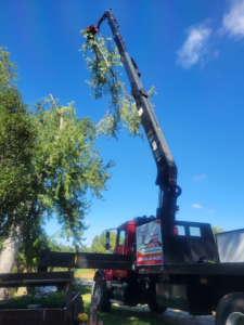 Broken Branch Tree Removal's crane truck performing tree trimming services in Broadalbin, NY.