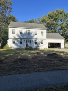 A tree service worker in a bucket truck trimming branches near power lines for Two Daughters Trees & Driveways in Saco, ME.