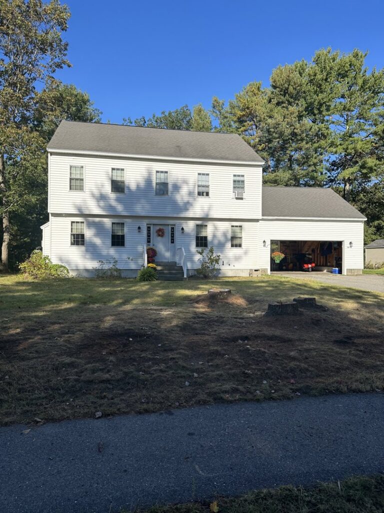 A tree service worker in a bucket truck trimming branches near power lines for Two Daughters Trees & Driveways in Saco, ME.
