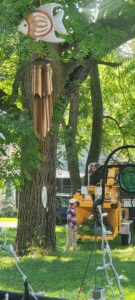 A tree worker trimming branches high in a tree with a wood chipper below by G.O.'s Tree Service in Pittsburgh, PA