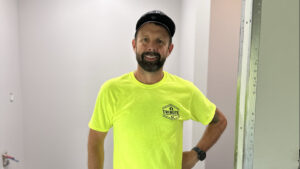 A friendly worker from Tribute Painting & Drywall standing in a newly painted room in St. Louis, MO.