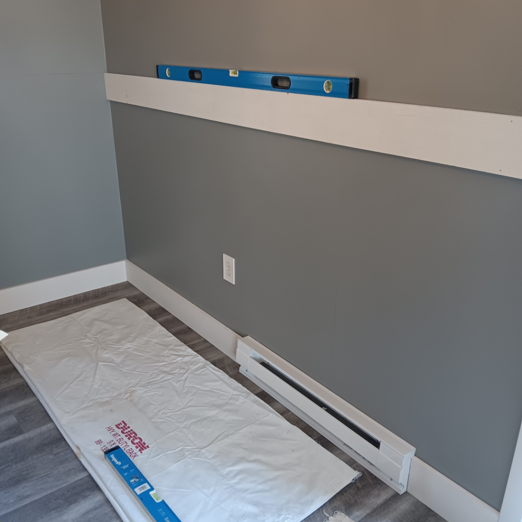 Trim installation in progress with a level and drop cloth on the floor by Carter's painting in Martinsburg, WV.