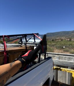 A richartehelps truck bed loaded with furniture, a grill, and other items ready for junk removal in Scottsdale, AZ.