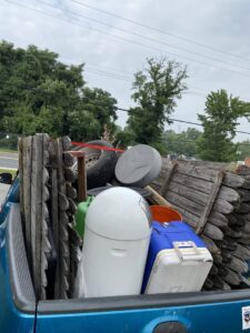 A truck bed loaded with old fence panels, tires, and other miscellaneous junk for removal by Navarro Demo LLC in Rockville, MD