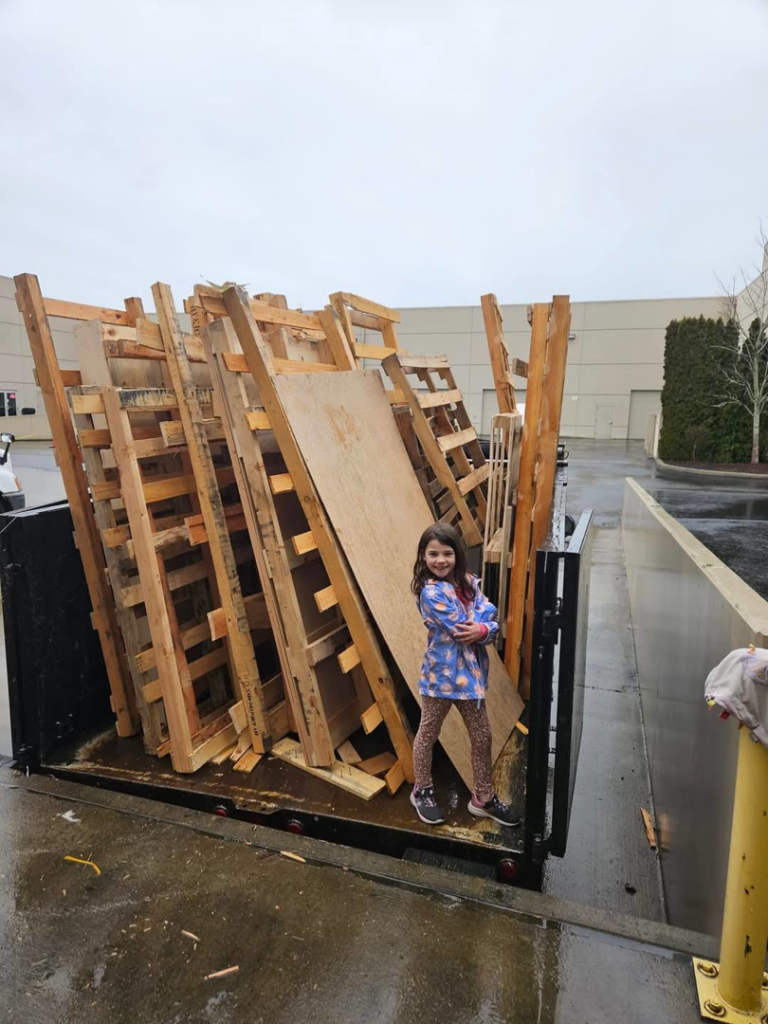 A truck bed loaded with wooden pallets and plywood for hauling by Glenn's Junk & Landscape Hauling in Renton, WA.