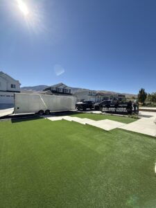 A truck delivering an empty dumpster on a trailer for Utah Valley Dumpsters in Provo, UT.