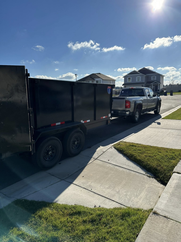 A pickup truck pulling a large dump trailer, ready for junk removal or light demolition services by Timber Moose Dynamics LLC in Spokane, WA.
