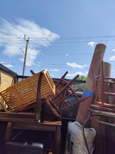 The back of a Wilsa Junk Removal truck filled with various household junk items in Fort Lauderdale, FL.