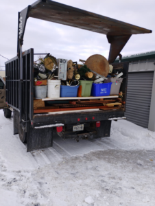 A dump truck loaded with various household junk and debris, showcasing a job by Cox Junk & Debris Removal in Buffalo, NY.
