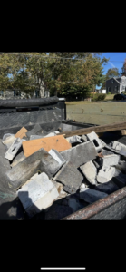 A truck bed filled with concrete blocks and construction debris, ready for removal by Trash Hogs in Worcester, MA.