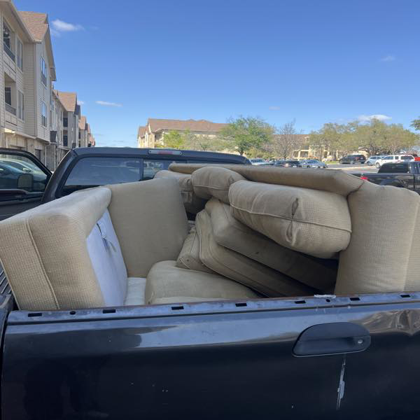 A truck bed filled with sofa cushions and furniture pieces for removal by ONLY Junk Removal Services in Austin, TX.