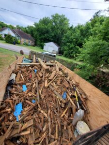 The back of a Sonny Day Junk Removal truck filled with wooden debris and trash after a cleanup job in Batesville, AR.
