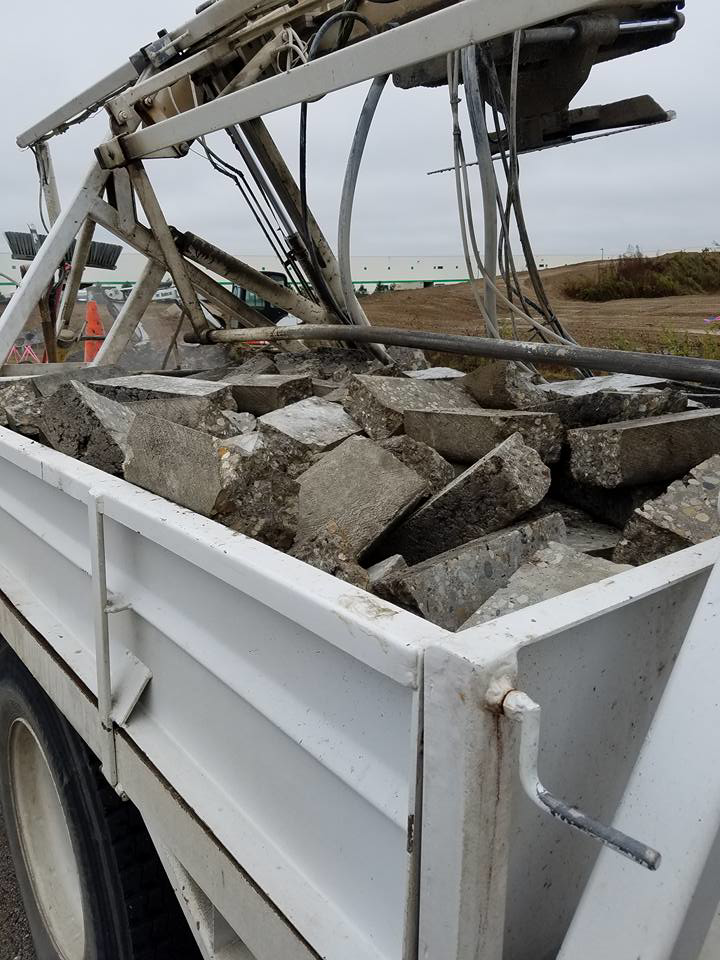 A truck bed filled with broken concrete, indicating demolition and debris removal by National Kurb Kut in Naperville, IL.