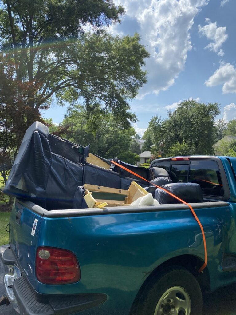A blue pickup truck loaded with disassembled furniture for junk removal by Navarro Demo LLC in Rockville, MD