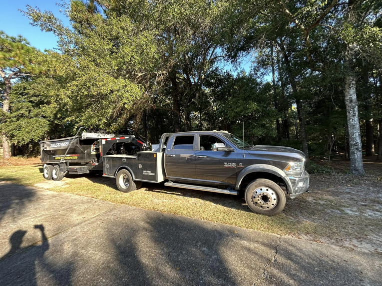 A Super Duper Dumpsters truck hauling an empty roll-off trailer for junk removal services in Mobile, AL.