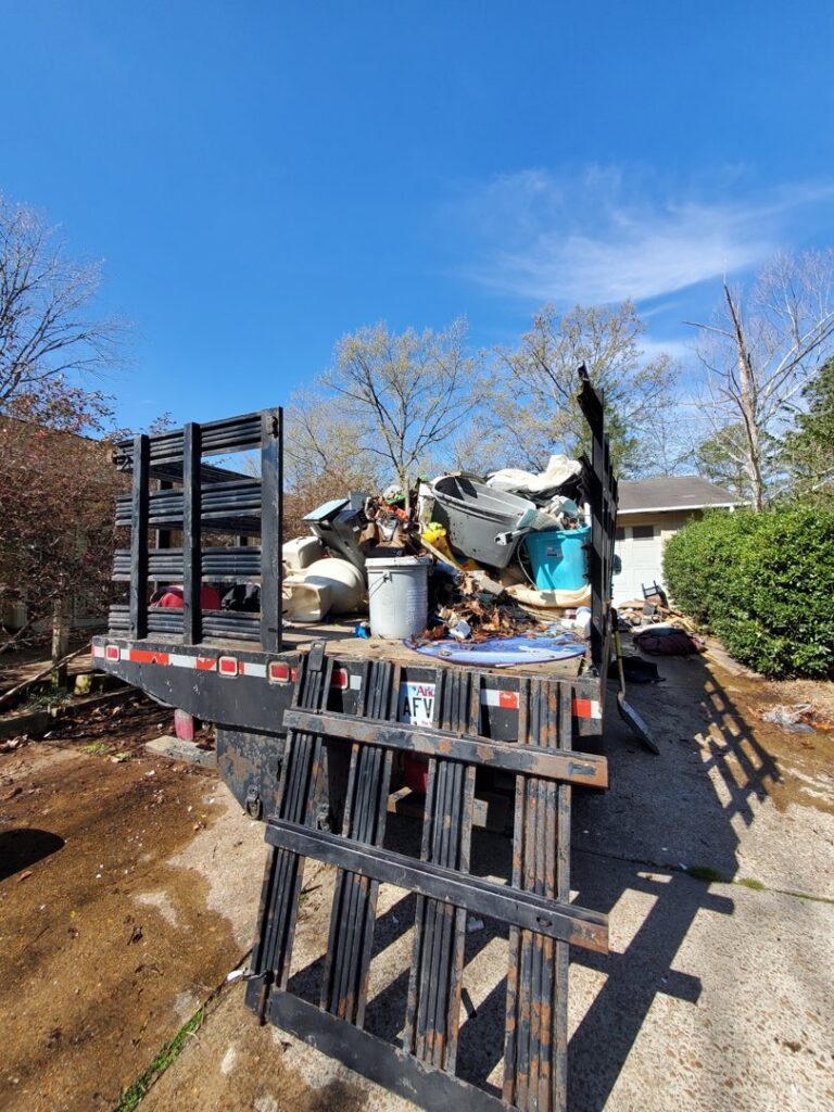 A Sonny Day Junk Removal truck loaded with various appliances and furniture for removal in Batesville, AR.