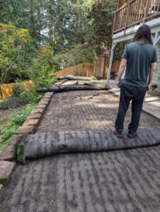 The back of a truck loaded with construction debris, including wood planks, concrete blocks, and roofing shingles, for removal by JUNK IN THEE TRUNK in Kent, WA.
