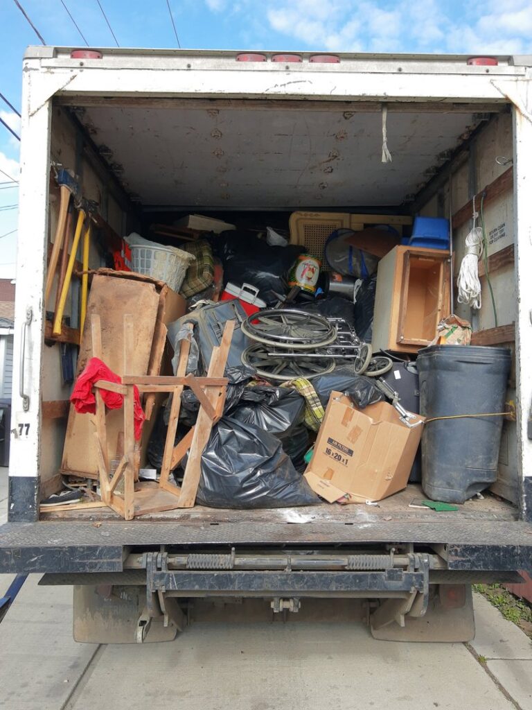 A junk removal truck loaded with various household junk and debris by In & Out Junk Removal Service LLC in Chicago, IL.