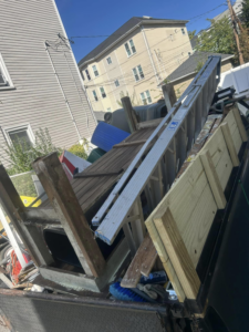 A truck bed loaded with a ladder, wooden planks, and various household debris for removal by Trash Hogs in Worcester, MA.