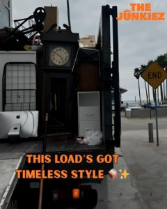 A The Junkiez Junk Removal truck loaded with an assortment of items like a clock, computer, and furniture in Los Angeles, CA.