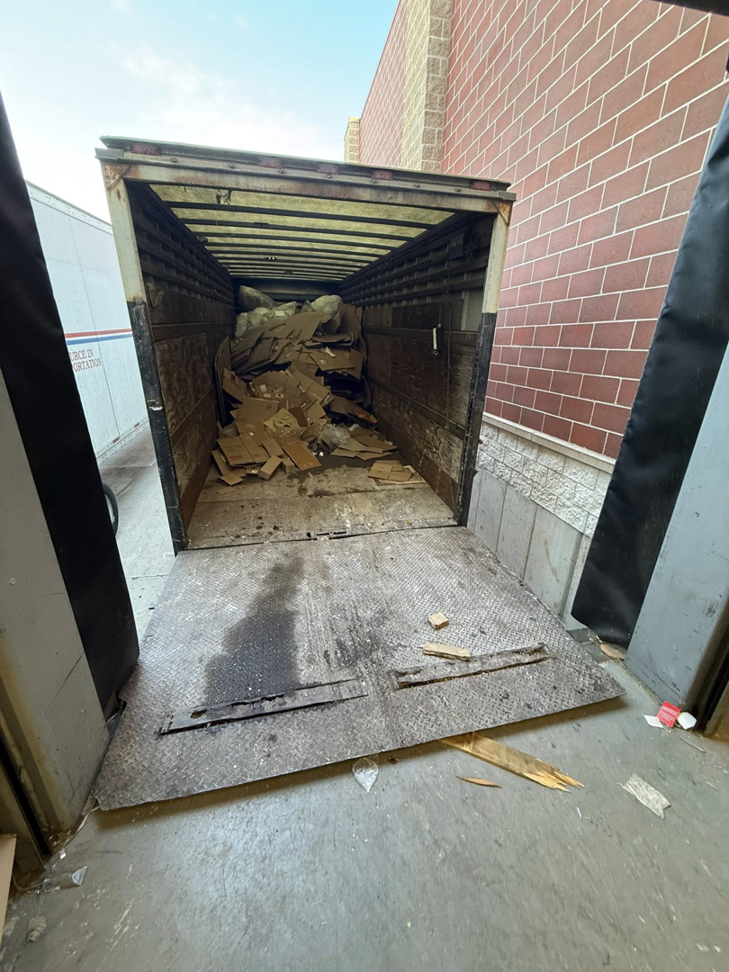 The back of a Fish Junk Removal And Trash Out Services LLC truck with the ramp down after a trash out service in Janesville, WI.