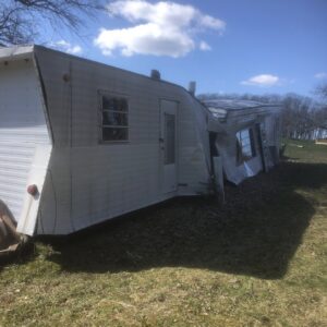 A truck and trailer next to a pile of demolition debris, indicating a hauling service by Tiny's Trash & Hauling Service L.L.C in Williamstown, VT