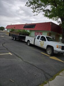 A pickup truck pulling a dump trailer filled with green waste and bushes by Rubble Removers LLC in Riverton, WY.