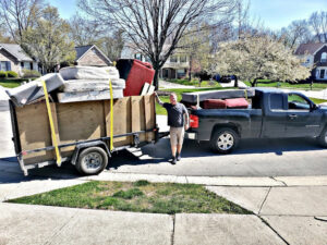 A truck and trailer loaded with mattresses and furniture, demonstrating a junk removal service by Indy Trash Guy in Fishers, IN.
