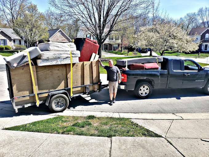 A truck and trailer loaded with mattresses and furniture, demonstrating a junk removal service by Indy Trash Guy in Fishers, IN.