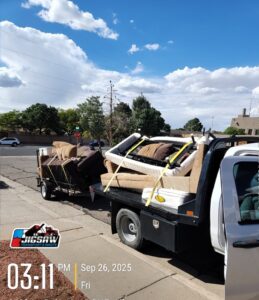 A truck and trailer loaded with mattresses and furniture for junk removal by Jigsaw Transport and Waste in Albuquerque, NM.