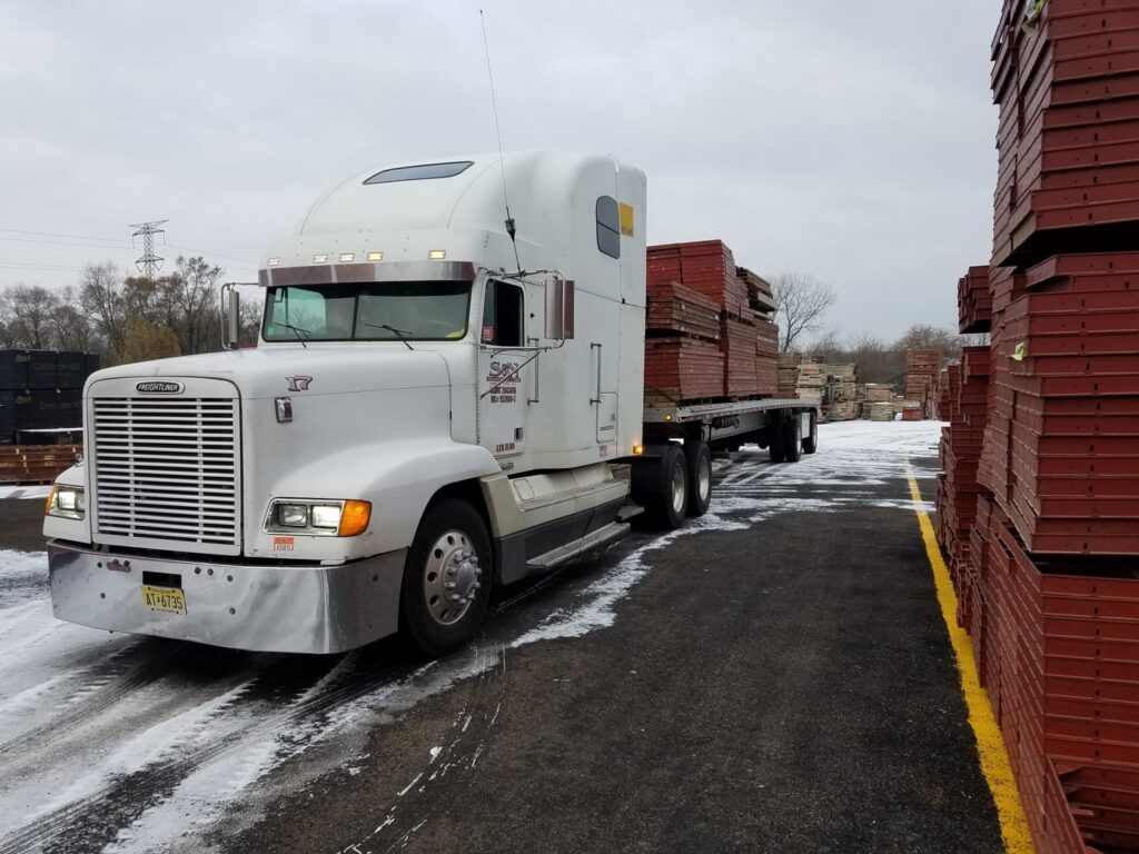 A semi-truck transporting concrete forms on a snowy day for Forming America, LLC in West Chicago, IL