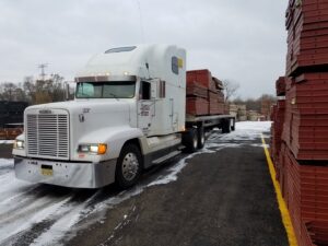 A semi-truck transporting concrete forms on a snowy day for Forming America, LLC in West Chicago, IL