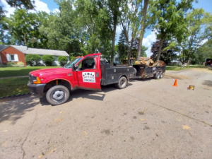 A Good Ol' Boys Tree Service truck with a trailer full of logs and wood debris in Lebanon, CT, after a tree removal.