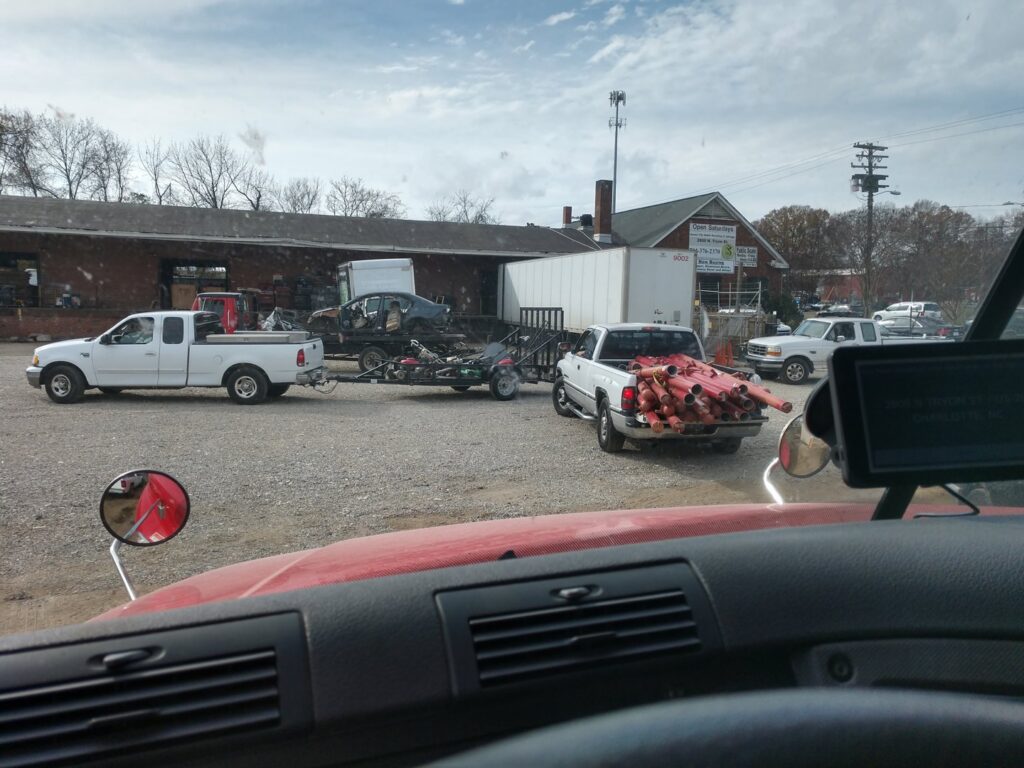 Multiple trucks and trailers bringing materials to the salvage yard at Queen City Metal Recycling & Salvage in Charlotte, NC.