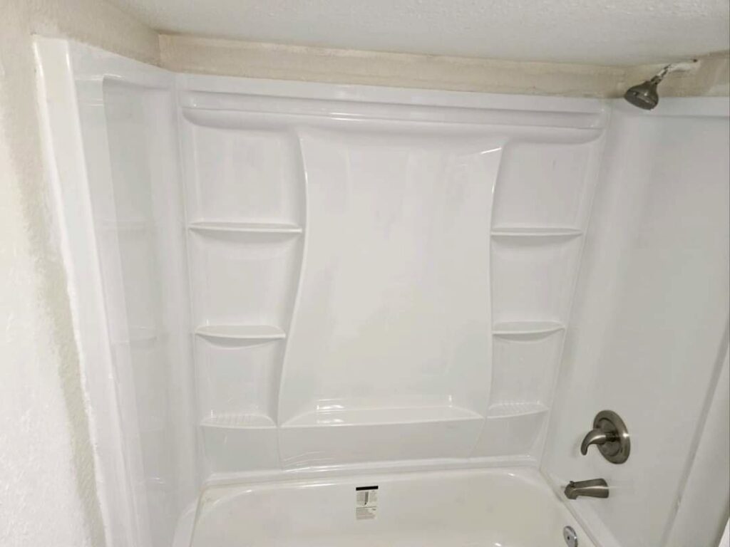A newly installed white tub and shower surround, demonstrating bathroom renovation services by Mr. Affordable LLC in Denver, CO.